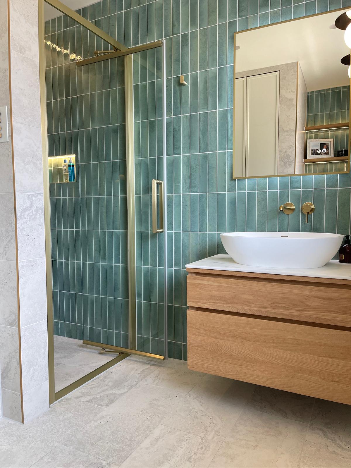 Contemporary bathroom with teal tiles and brass fixtures