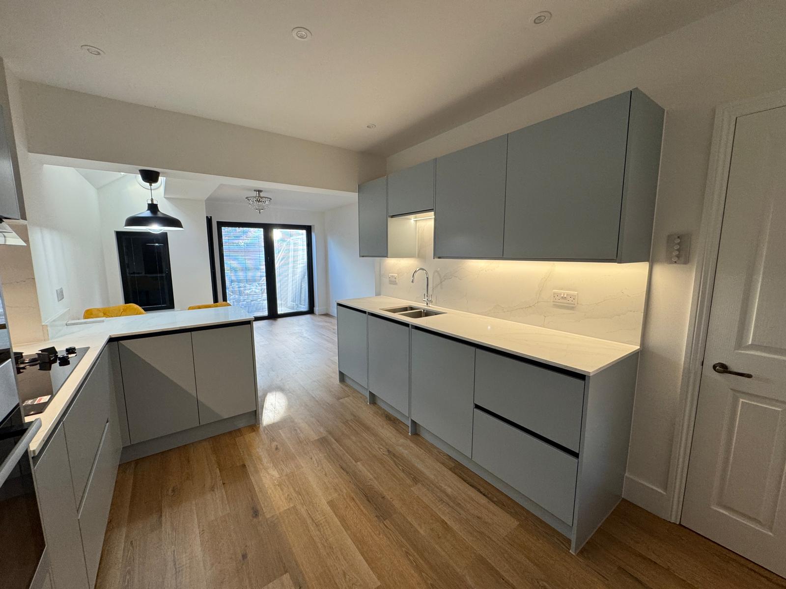 Sage green kitchen with brass pendant lighting