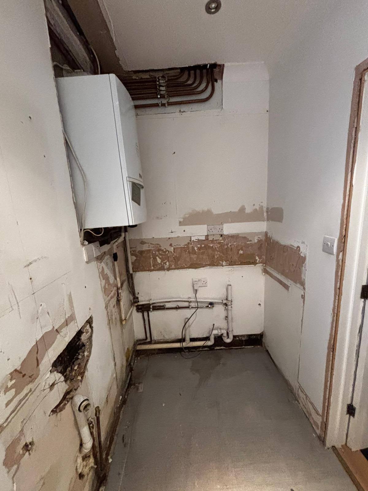 Before: the old boiler and pipework