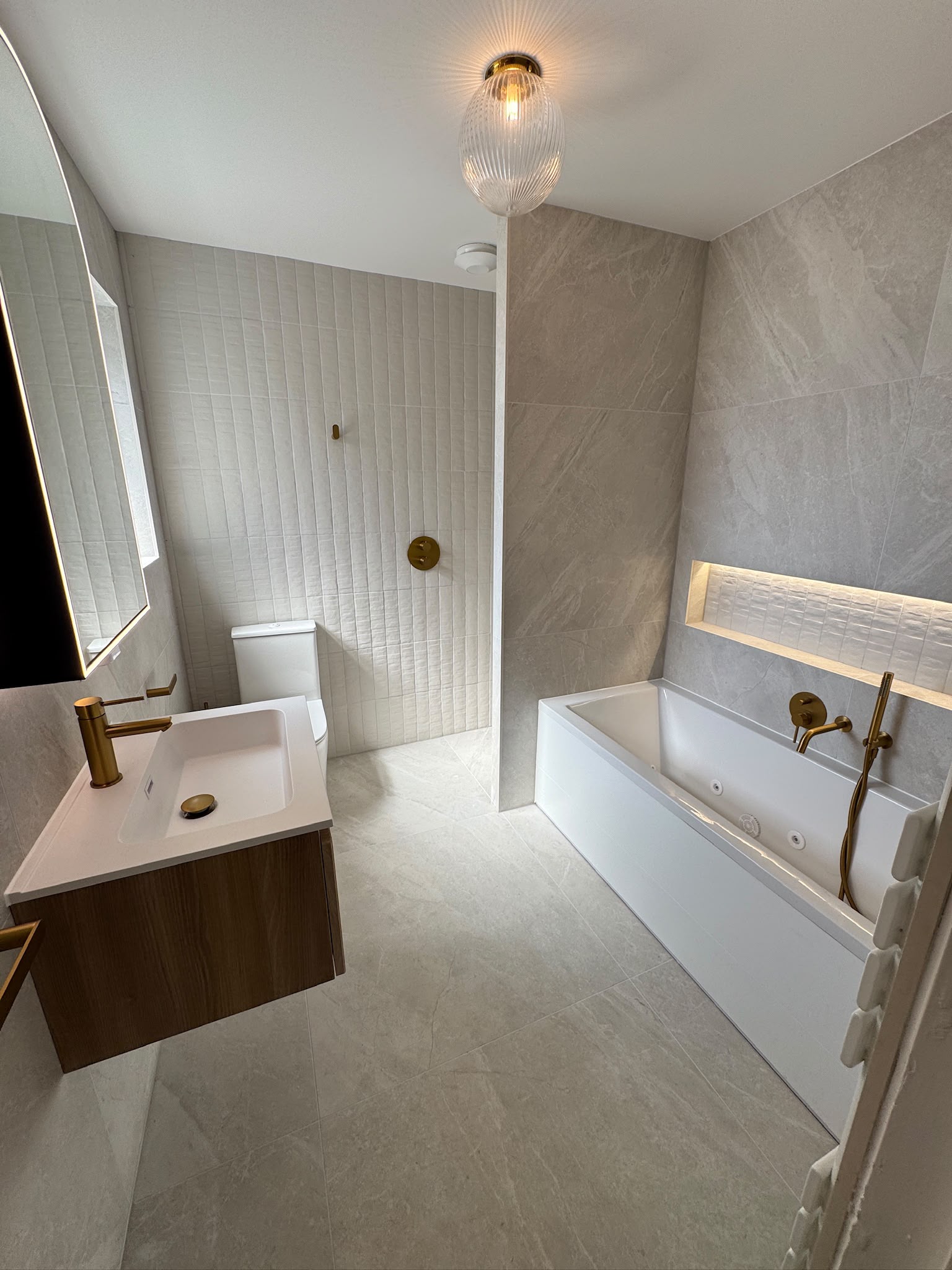 Walk-in shower with no screens beside the bath