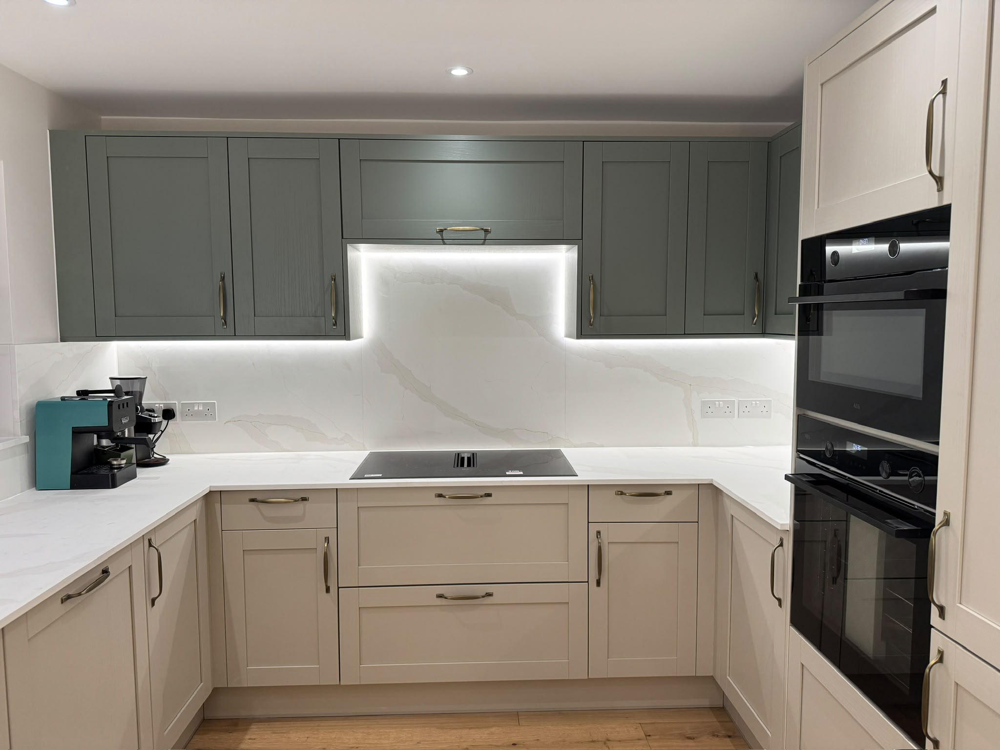 Shaker kitchen with stone worktops and a warm oak floor