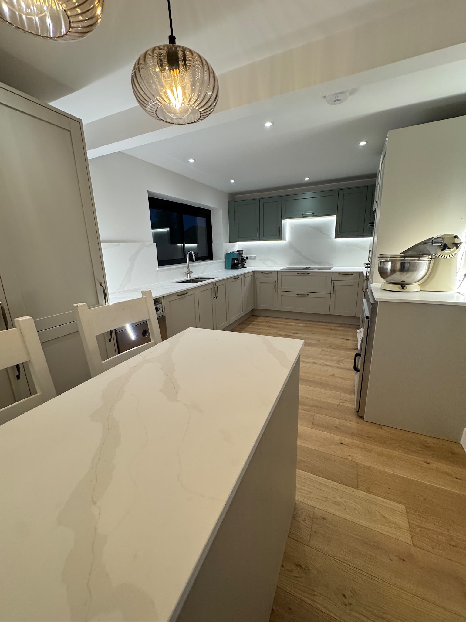 Island with stone worktop and glass pendant light