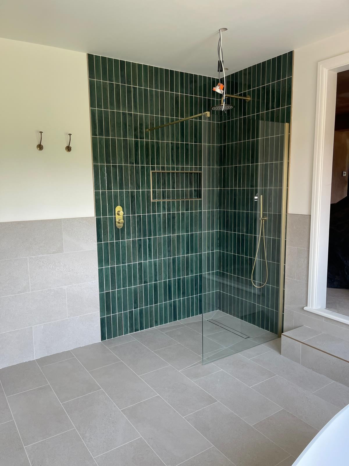 Walk-in shower with forest-green vertical tiles