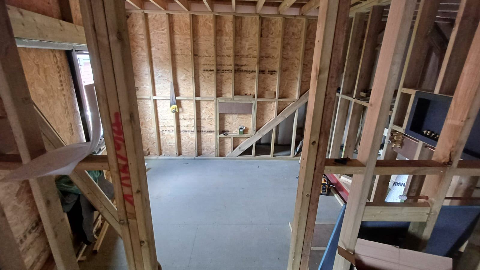 Before: bare timber studwork and concrete floor