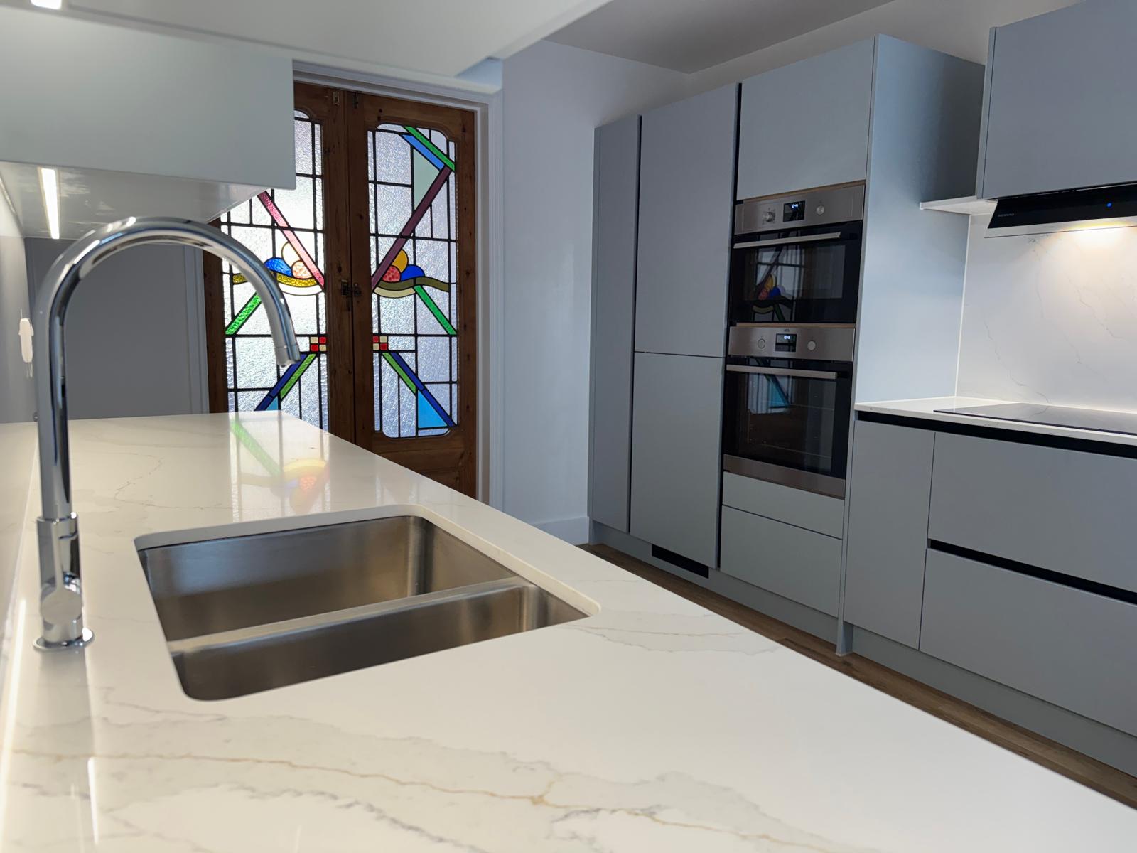 Island sink with a stained-glass door beyond