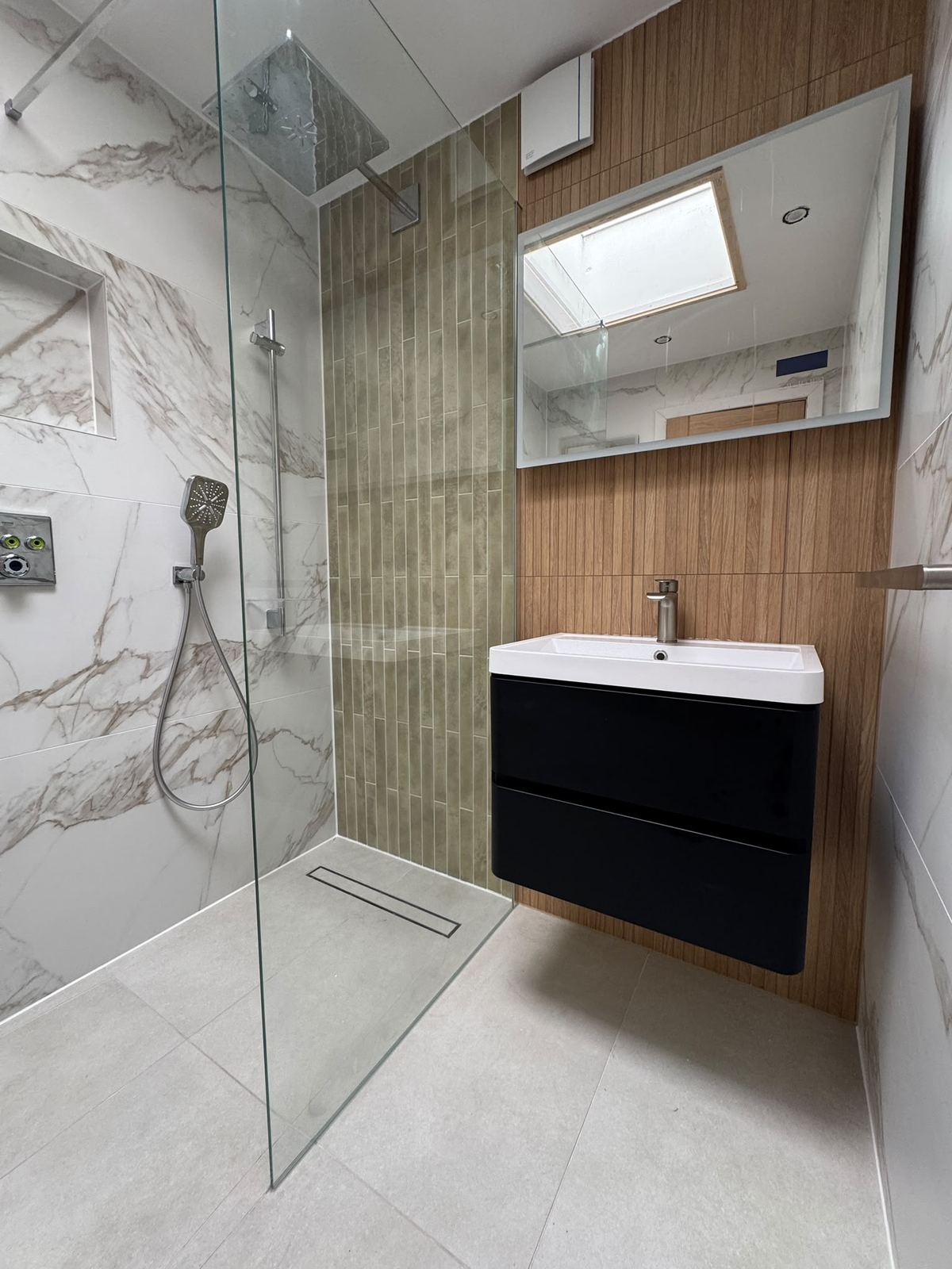 Walk-in shower with marble-look walls and black wall-hung vanity