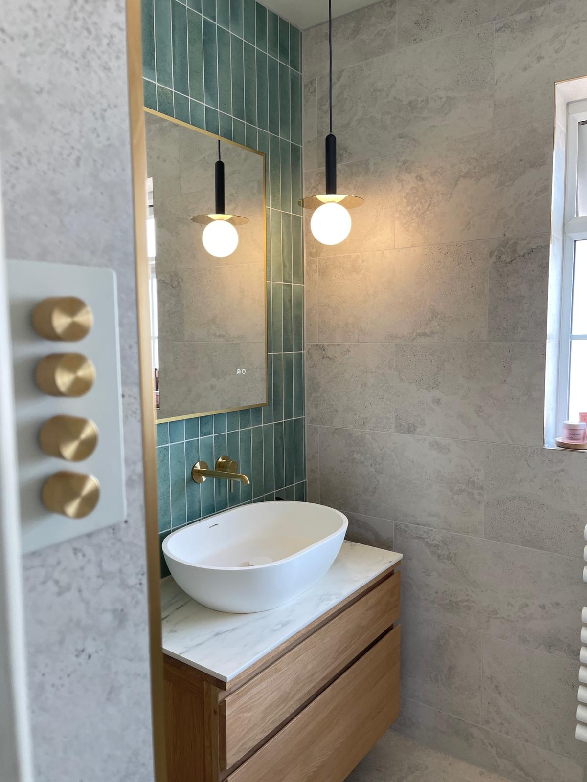 Oak vanity with countertop basin, pendant lights and brushed brass controls