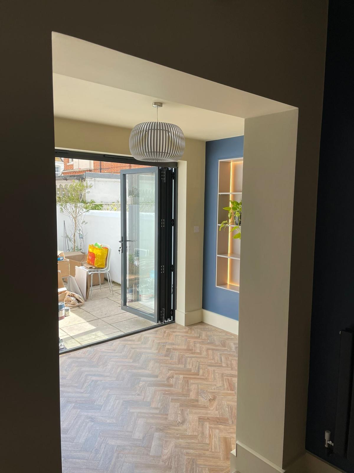 Looking through to the garden bifolds, with the shelving glowing beyond