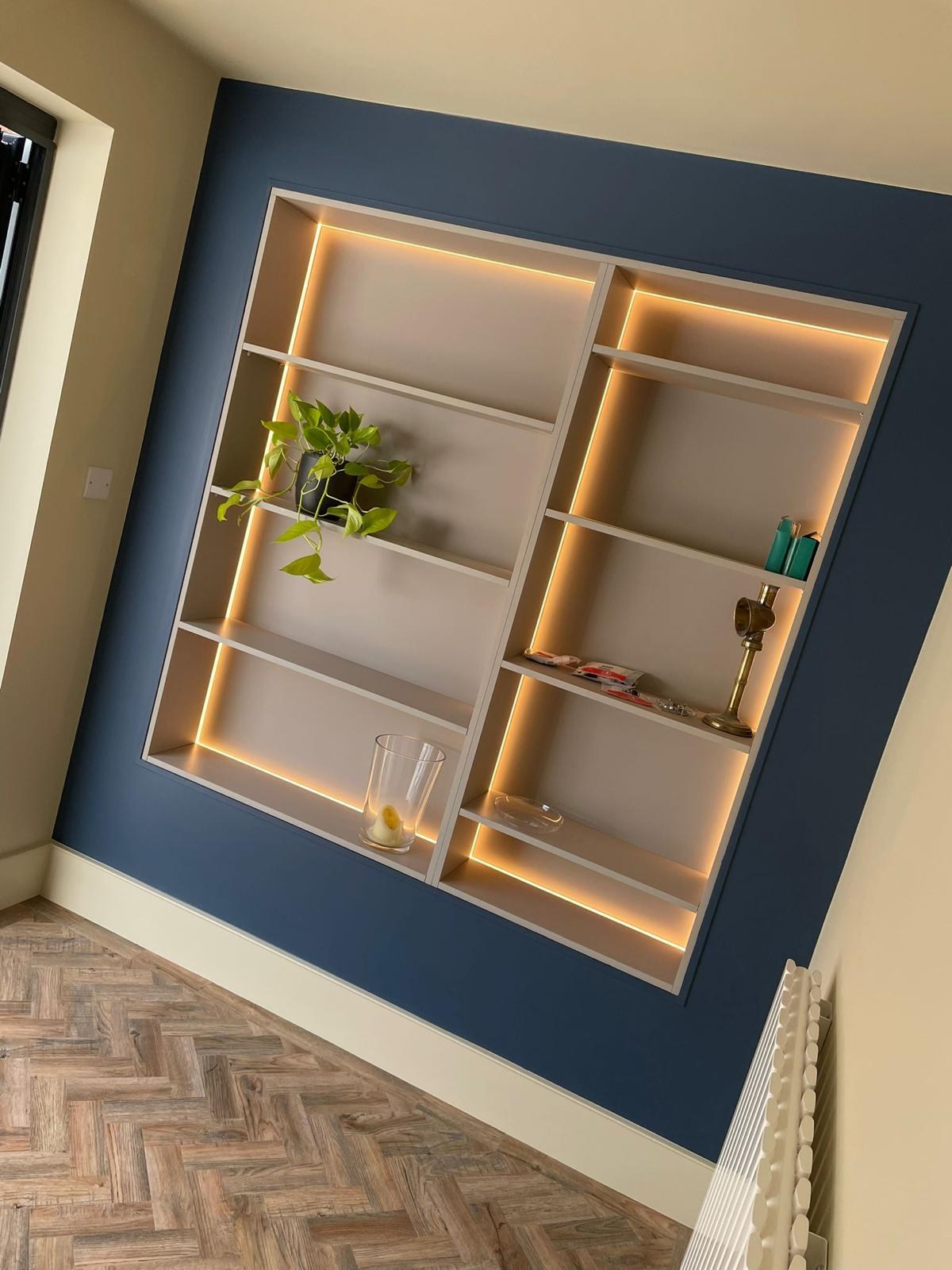 Bespoke lit alcove shelving on a navy wall
