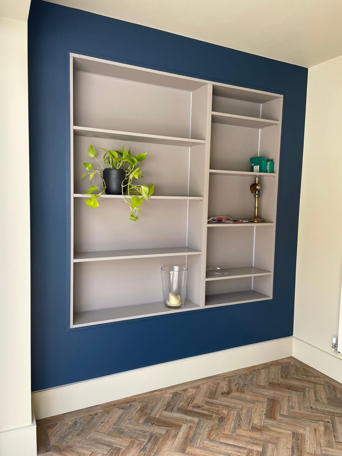 Lit alcove shelving with trailing plants, straight on