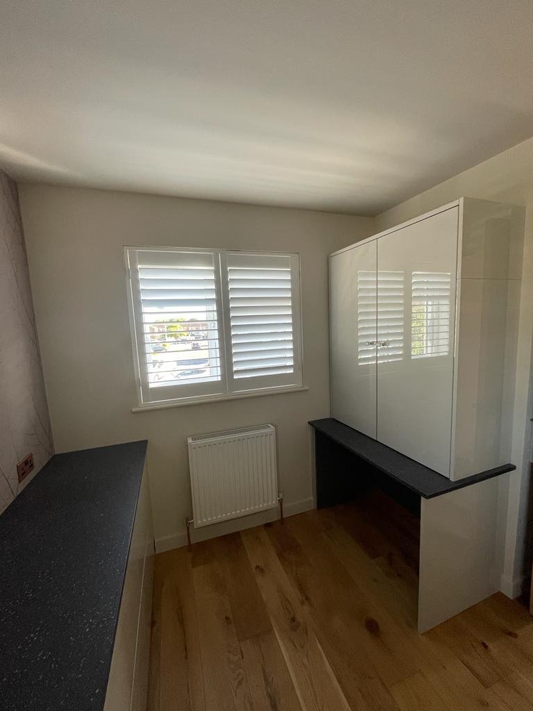Fitted desk unit built into the corner by the window
