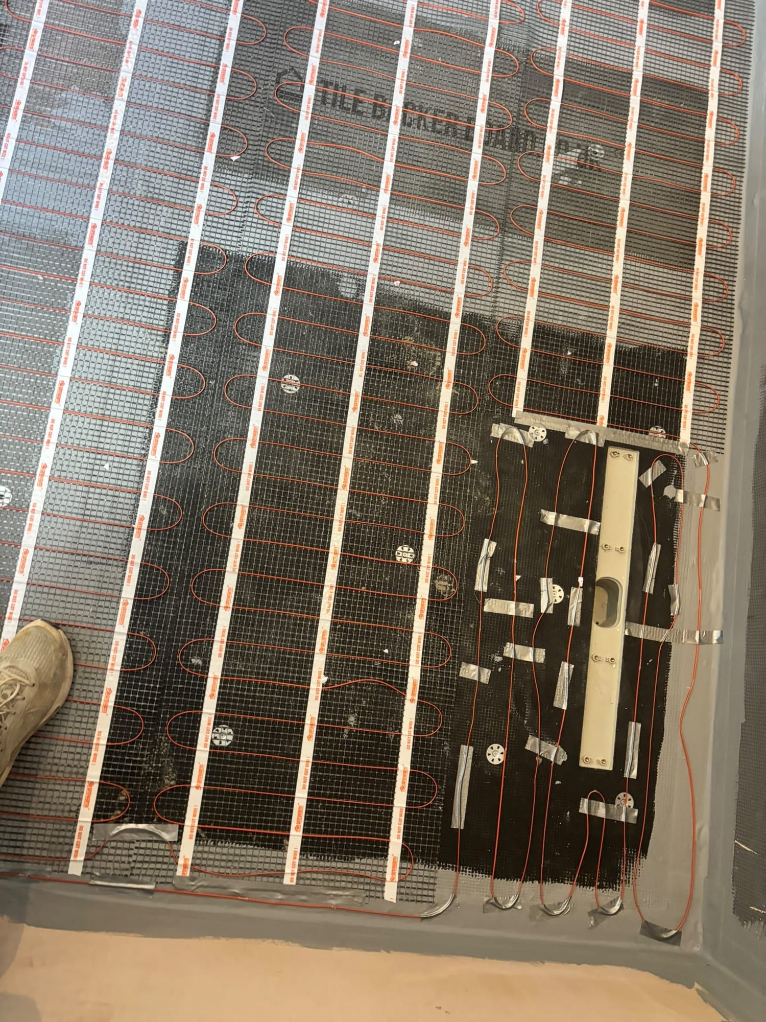 Close-up of the heating cables taped down over tile backer board
