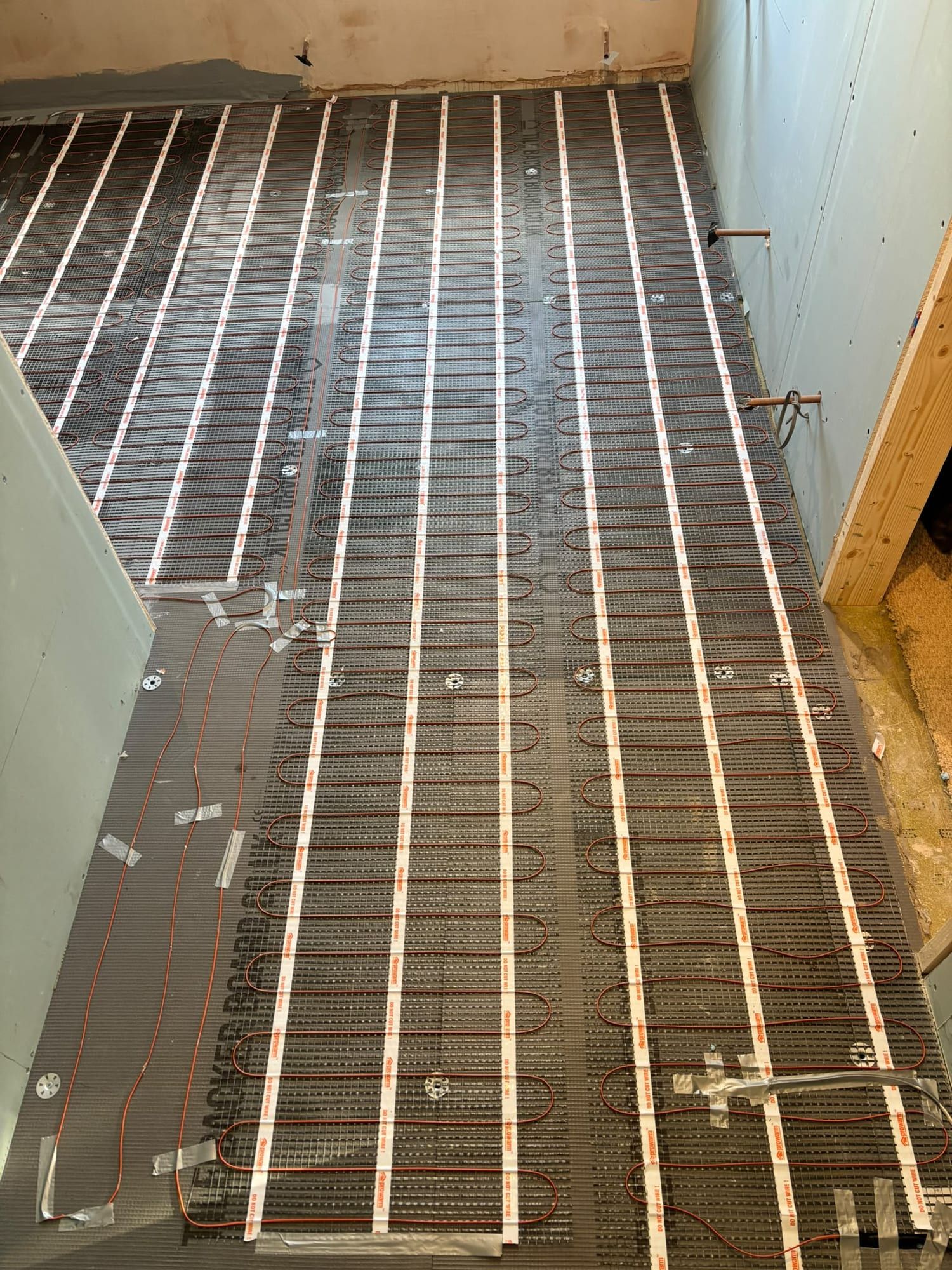 Heating mats running the length of the floor before tiling